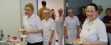 Reinigungspersonal stehend am Buffet mit Tellern in den Händen